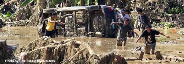 Residents wade in knee-deep mud in a subdivision hit by flash floods caused by Typhoon Washi in Iligan city in the southern Philippines island of Mindanao on Dec. 19, 2011.